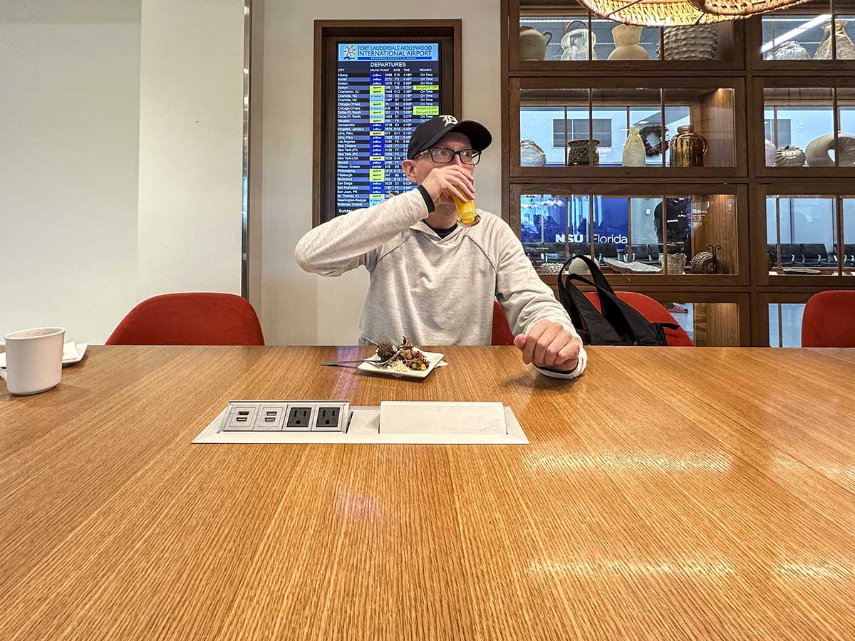 Scott enjoying a meal and a drink in the Amex Escape Lounge FLL 