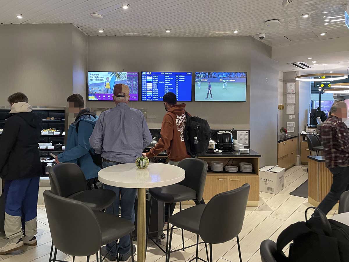 Plaza Premium Lounge YVR televisions, flight information display, and seating area