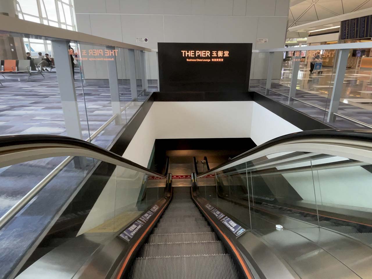 Going down the escalator into Cathay Pacific The Pier Lounge Hong Kong