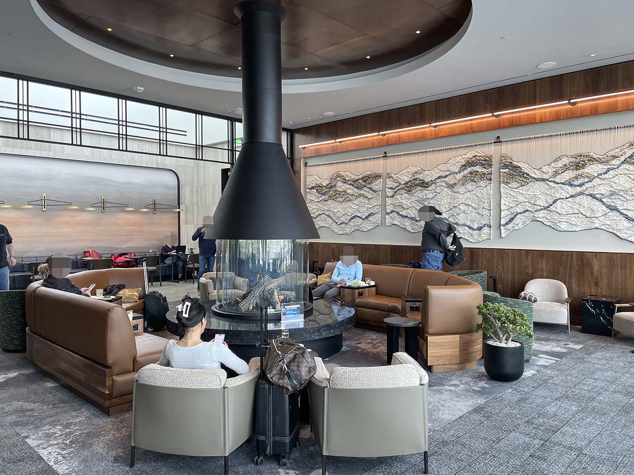 Central fireplace with seating around it in the SLC Amex Lounge