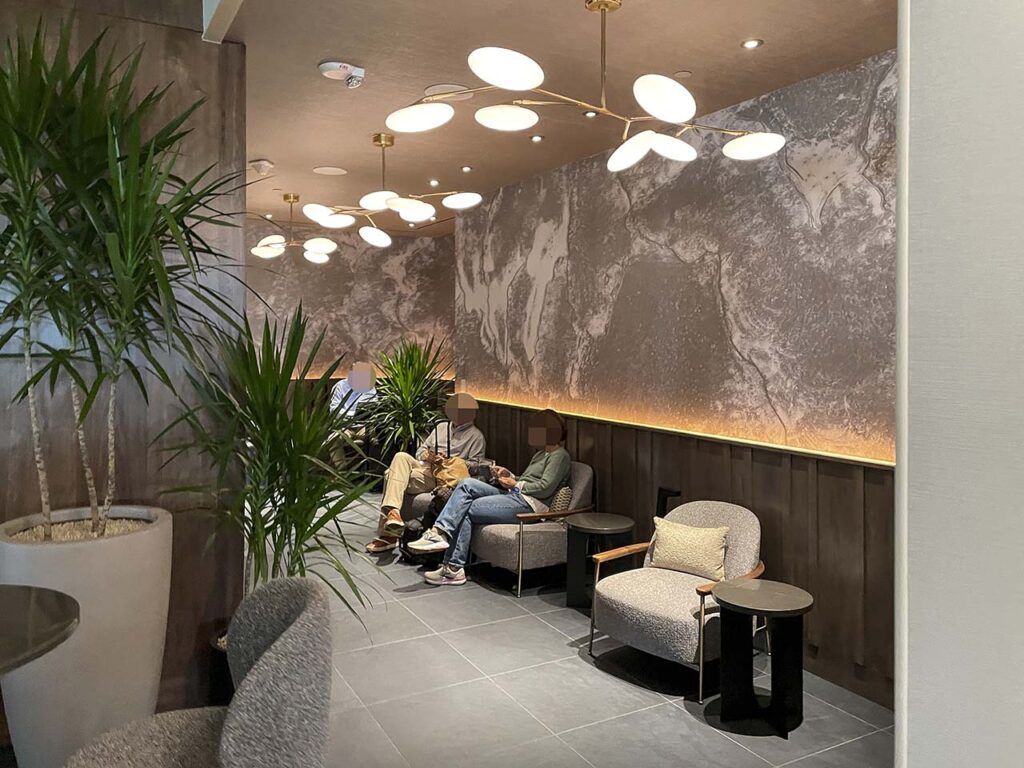 Semiprivate seating area with overhead lighting in the SLC Amex Lounge